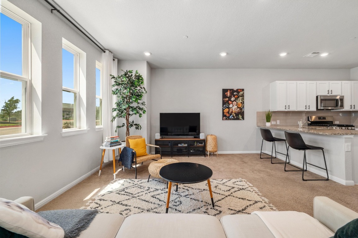 9015 Cattle Baron Path, Unit 403 Austin, TX 78747 - Photo 5 of 40 a living room with furniture and a flat screen tv