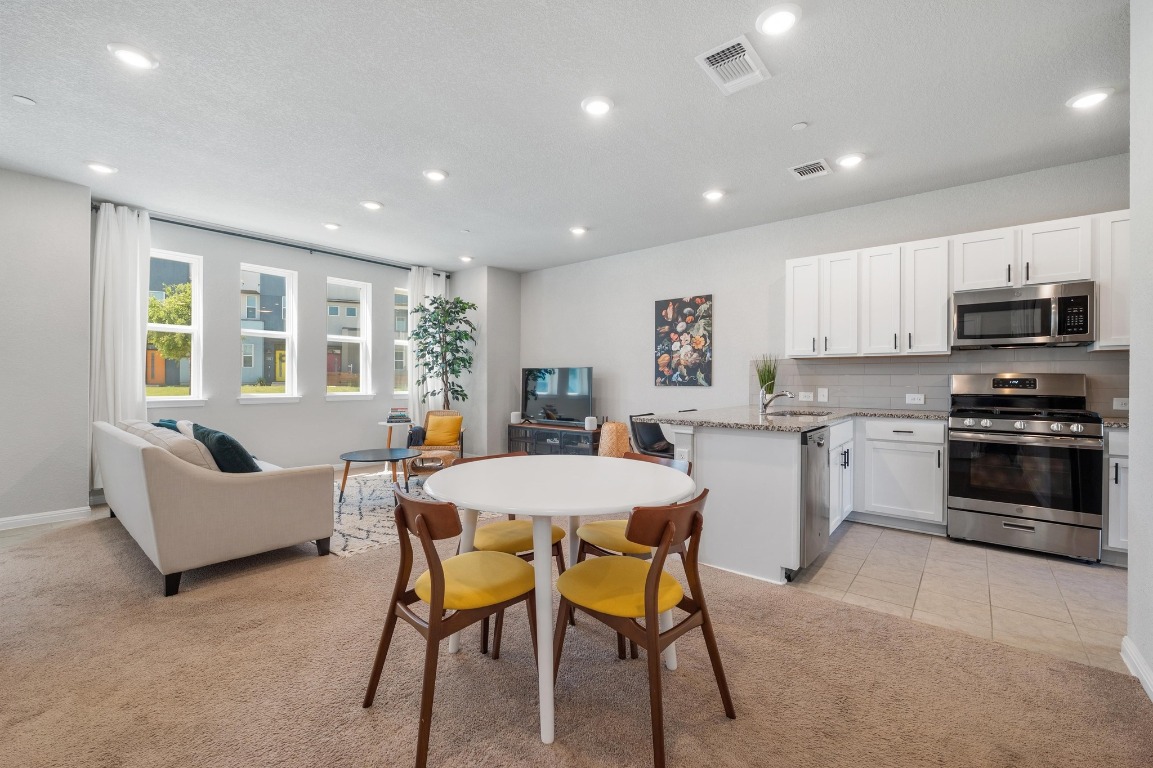 9015 Cattle Baron Path, Unit 403 Austin, TX 78747 - Photo 7 of 40 a kitchen with a table and chairs in it