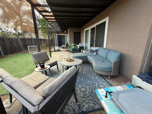 a dining room with stainless steel appliances furniture a rug and a large window
