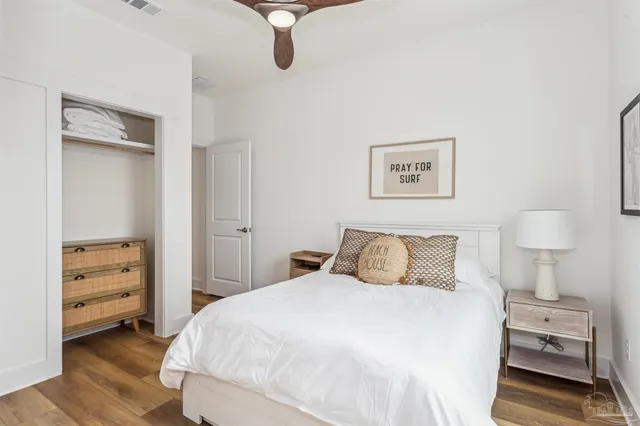 a bedroom with a bed and a flat tv screen on wall