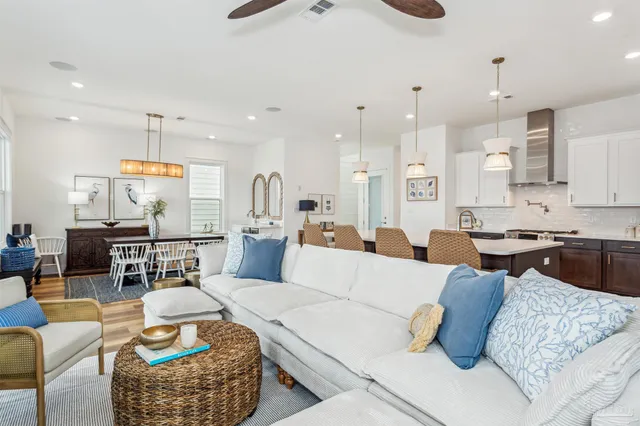 a living room with furniture kitchen view and a chandelier