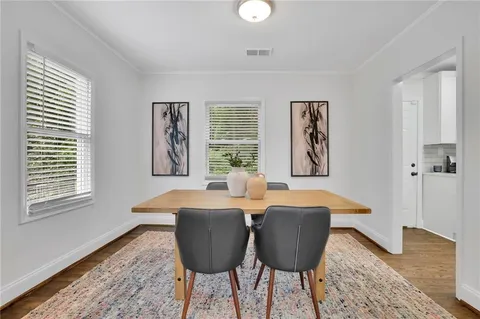 a kitchen with stainless steel appliances white cabinets a sink a stove a microwave and wooden floors