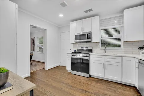 a kitchen with white cabinets and stainless steel appliances