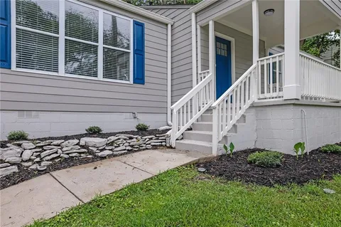 a view of a house with a small yard and wooden fence