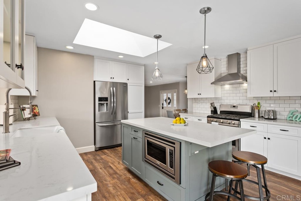 1815 Bailey Drive Oceanside, CA 92054 - Photo 10 of 34 a kitchen with stainless steel appliances a stove a sink island and refrigerator