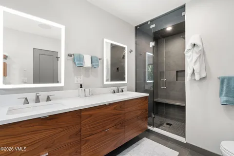 a bathroom with a double vanity sink mirror double and shower