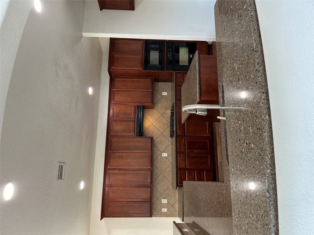 1374 Red Stag Place Round Rock, TX 78665 - Photo 5 of 15 a kitchen with kitchen island granite countertop wooden cabinets a oven and a granite counter with a stove