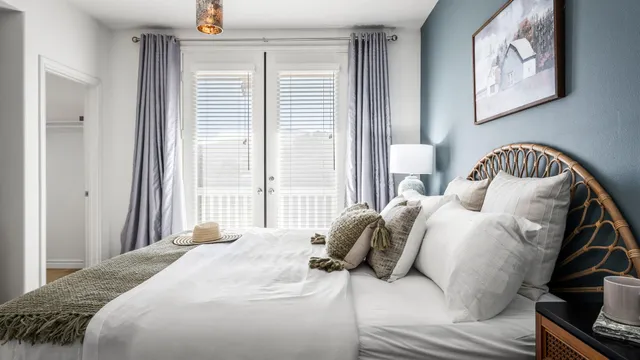 a bedroom with a bed and a lamp on dresser