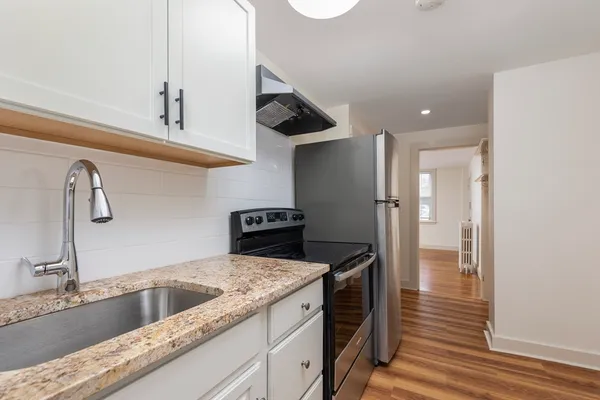 a kitchen with stainless steel appliances granite countertop a sink and a refrigerator