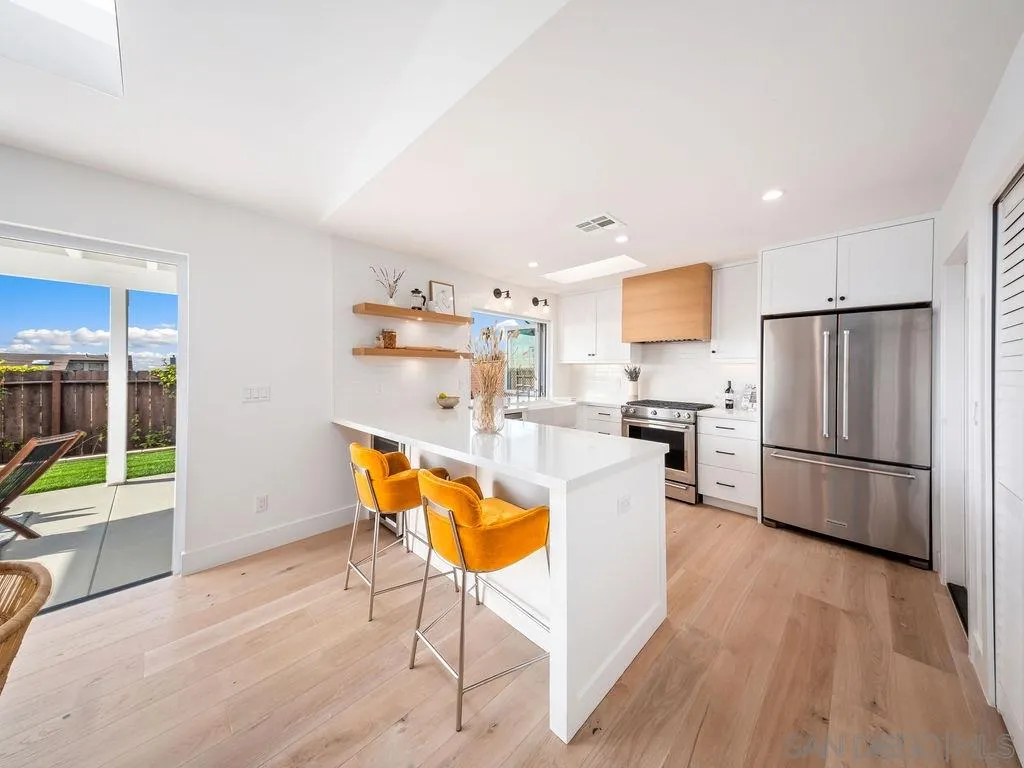 1710 Legaye Drive Cardiff, CA 92007 - Photo 11 of 43 a kitchen with stainless steel appliances granite countertop a refrigerator a stove a sink dishwasher and a dining table with wooden floor
