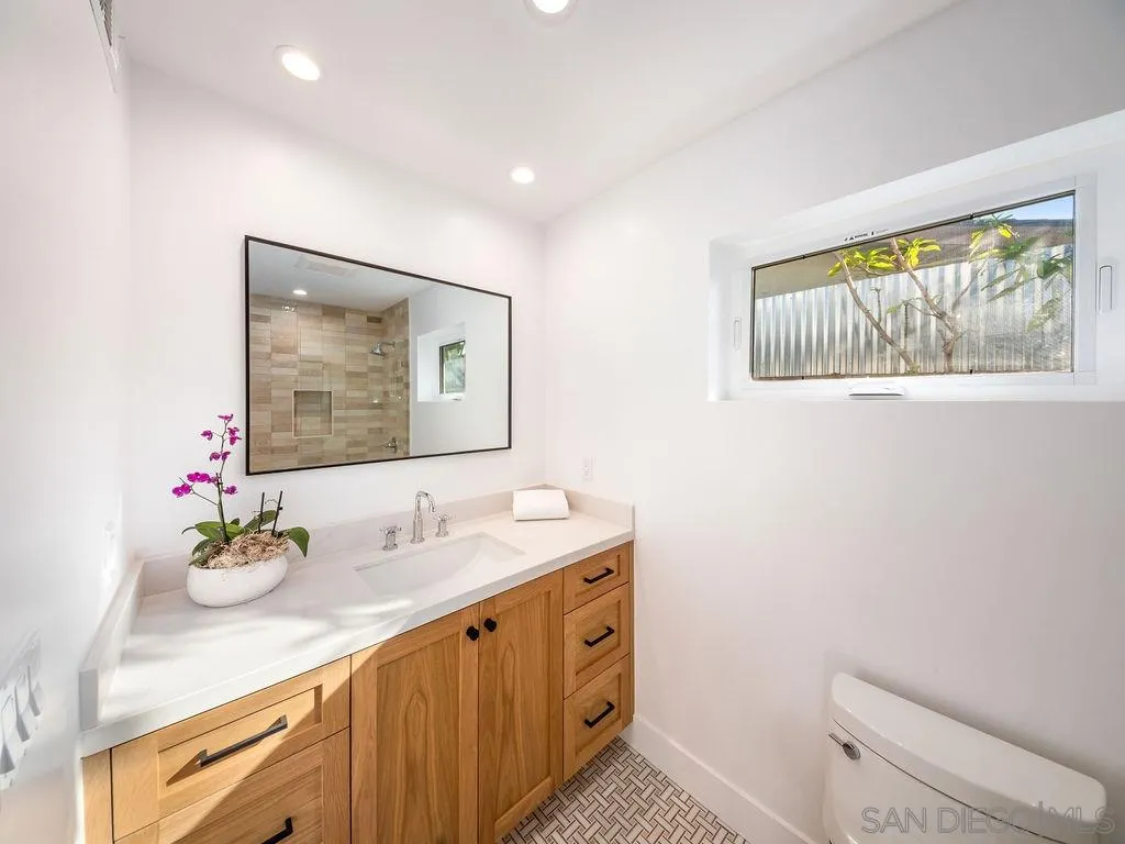 1710 Legaye Drive Cardiff, CA 92007 - Photo 28 of 43 a bathroom with a granite countertop sink mirror vanity and toilet