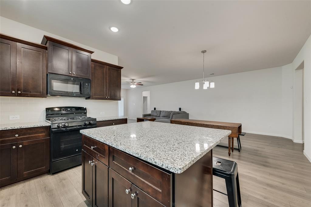 624 Hazeltine Road Red Oak, TX 75154 - Photo 14 of 37 a kitchen with a stove a sink and a refrigerator