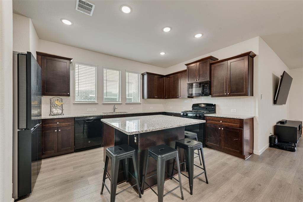 624 Hazeltine Road Red Oak, TX 75154 - Photo 16 of 37 a kitchen with stainless steel appliances granite countertop wooden cabinets a refrigerator a stove a microwave and a refrigerator