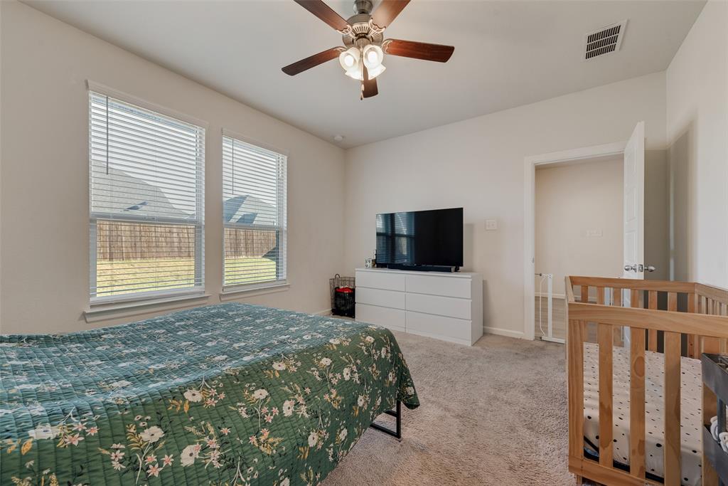 624 Hazeltine Road Red Oak, TX 75154 - Photo 23 of 37 a bedroom with a bed and a flat screen tv