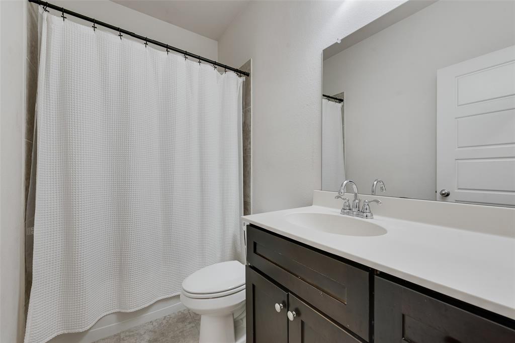 624 Hazeltine Road Red Oak, TX 75154 - Photo 27 of 37 a bathroom with a sink a toilet and a mirror
