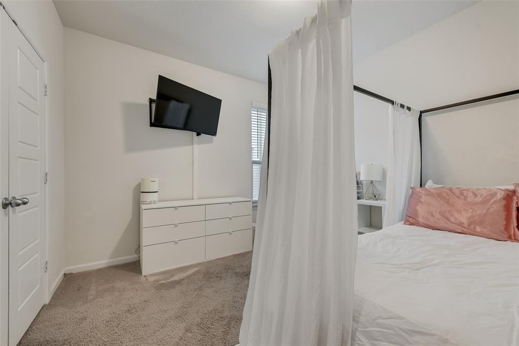 624 Hazeltine Road Red Oak, TX 75154 - Photo 29 of 37 a bedroom with a bed and a flat screen tv