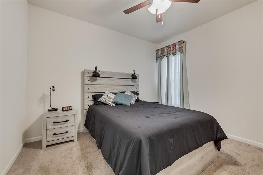 624 Hazeltine Road Red Oak, TX 75154 - Photo 34 of 37 a bedroom with a bed and a chandelier