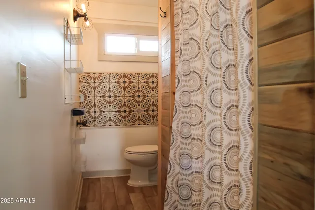 a bathroom with a toilet and shower curtain
