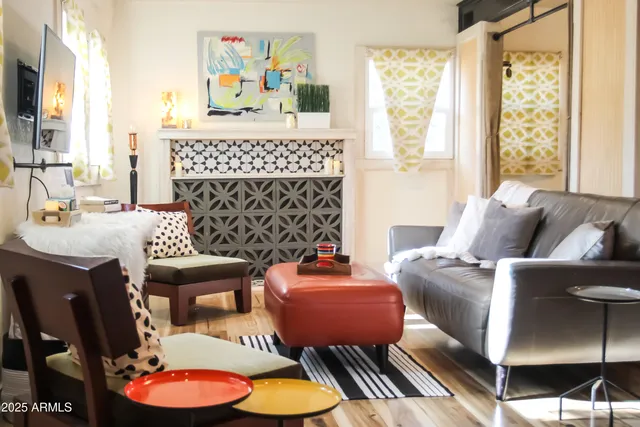 a living room with furniture a fireplace and a large window