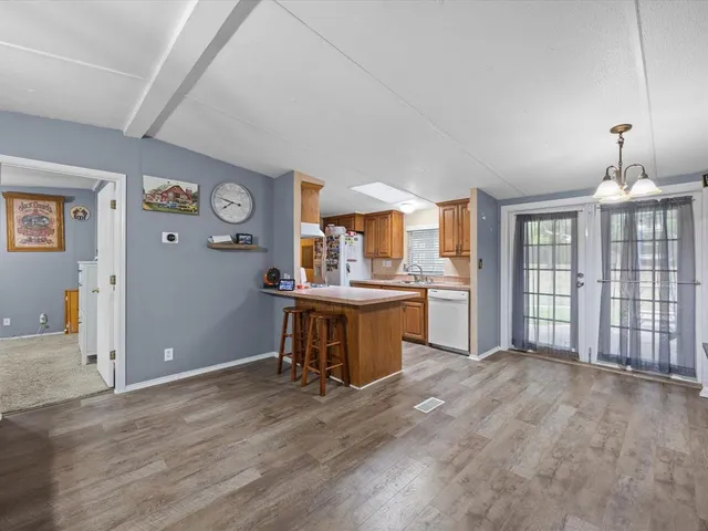 a view of a kitchen with wooden floor and electronic appliances