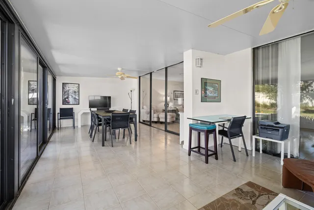 a dining room with furniture and a large window