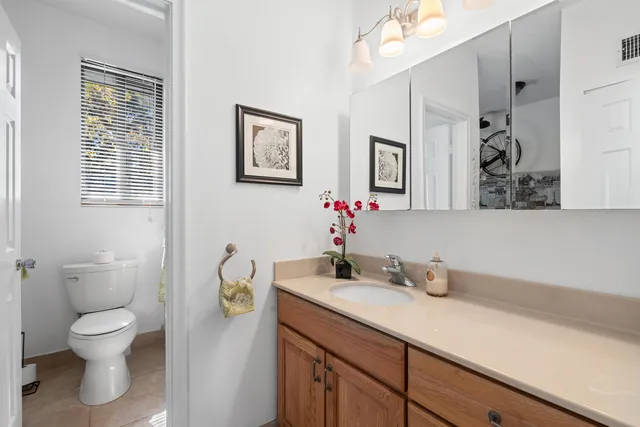a bathroom with a granite countertop toilet sink and mirror