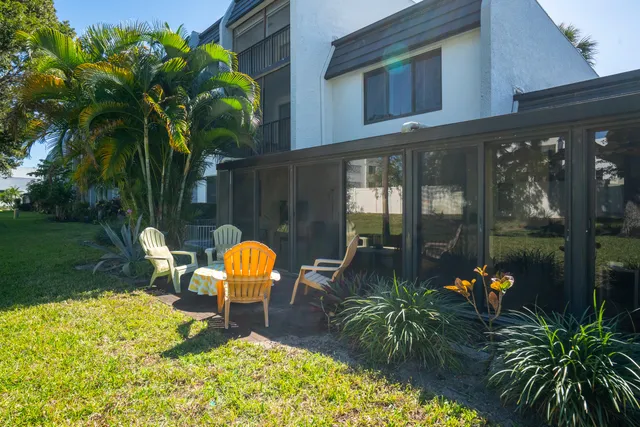 a view of a house with a yard and potted plants