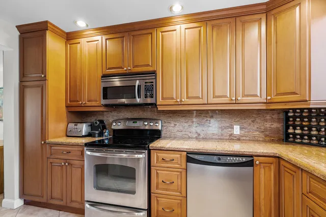 a kitchen with granite countertop a stove top oven microwave and cabinets