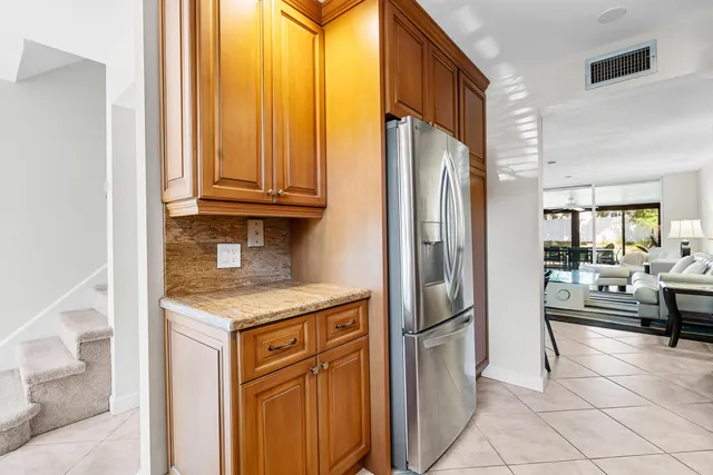 a kitchen with stainless steel appliances granite countertop a refrigerator and a sink