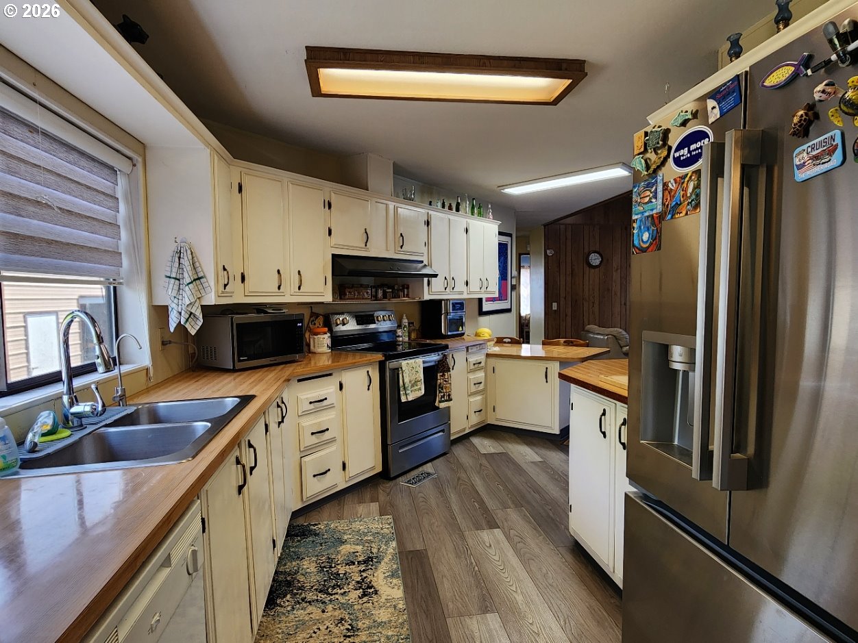 430 Birch Street Drain, OR 97435 - Photo 7 of 33 a kitchen with stainless steel appliances granite countertop a refrigerator a sink dishwasher a stove and white countertops with wooden floor