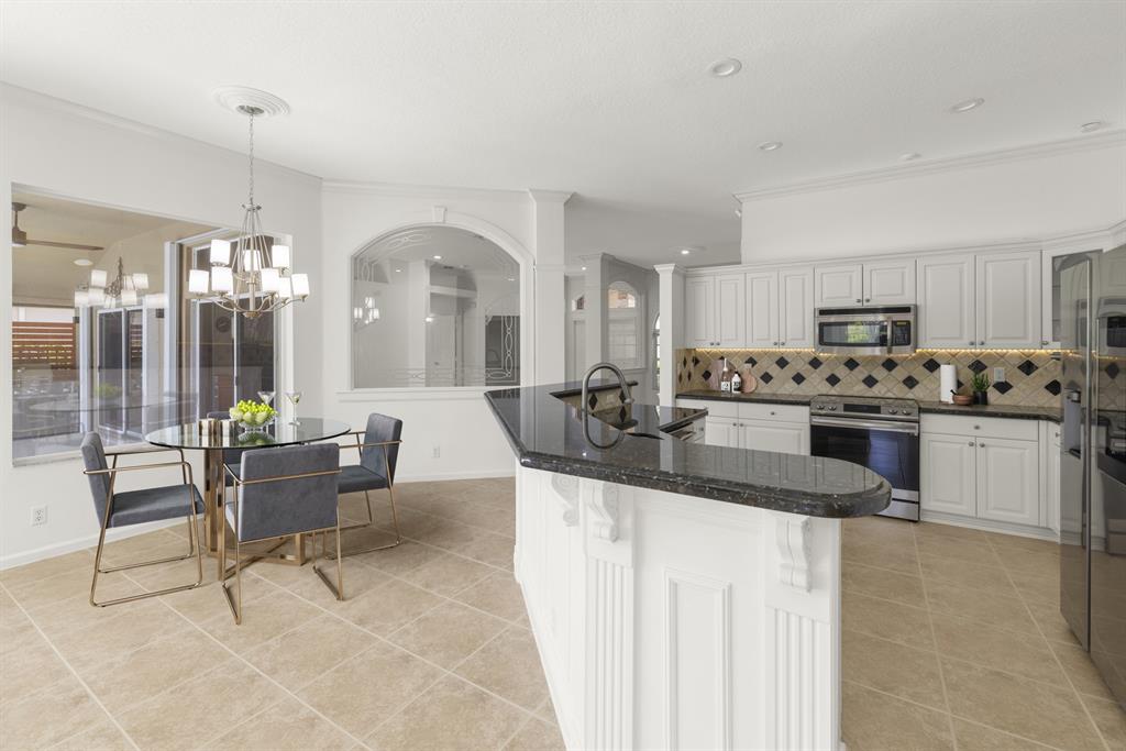 3707 Oak Ridge Circle Weston, FL 33331 - Photo 8 of 47 a kitchen with stainless steel appliances kitchen island granite countertop a sink and cabinets