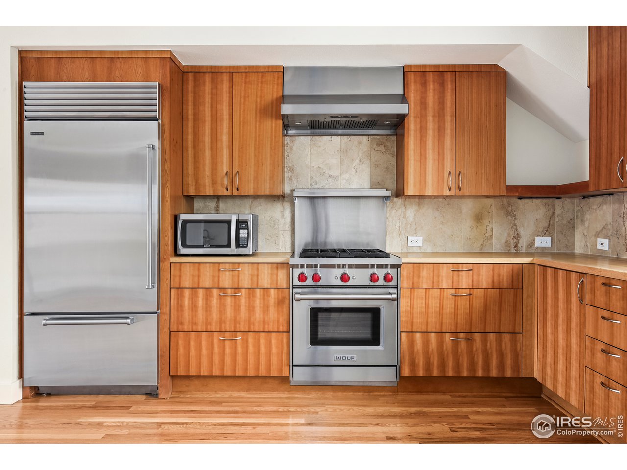 1933 Pearl Street, Unit 7 Boulder, CO 80302 - Photo 5 of 21 a kitchen with stainless steel appliances granite countertop a refrigerator a stove and a sink with wooden cabinets