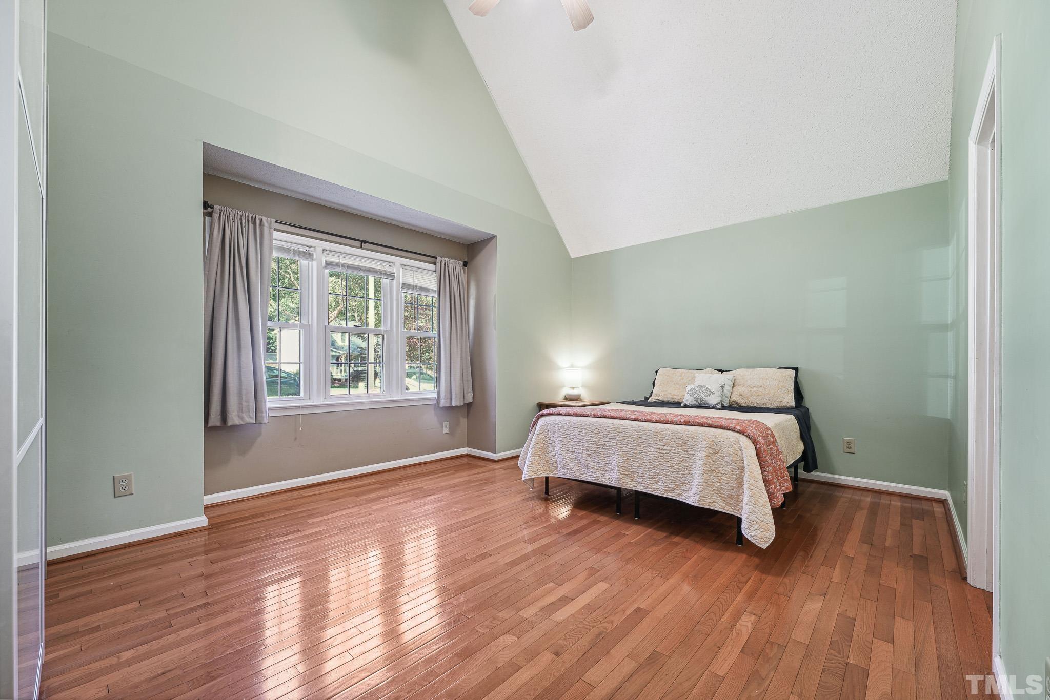 6712 Hammersmith Drive Raleigh, NC 27613 - Photo 14 of 26 a spacious bedroom with a bed and wooden floor