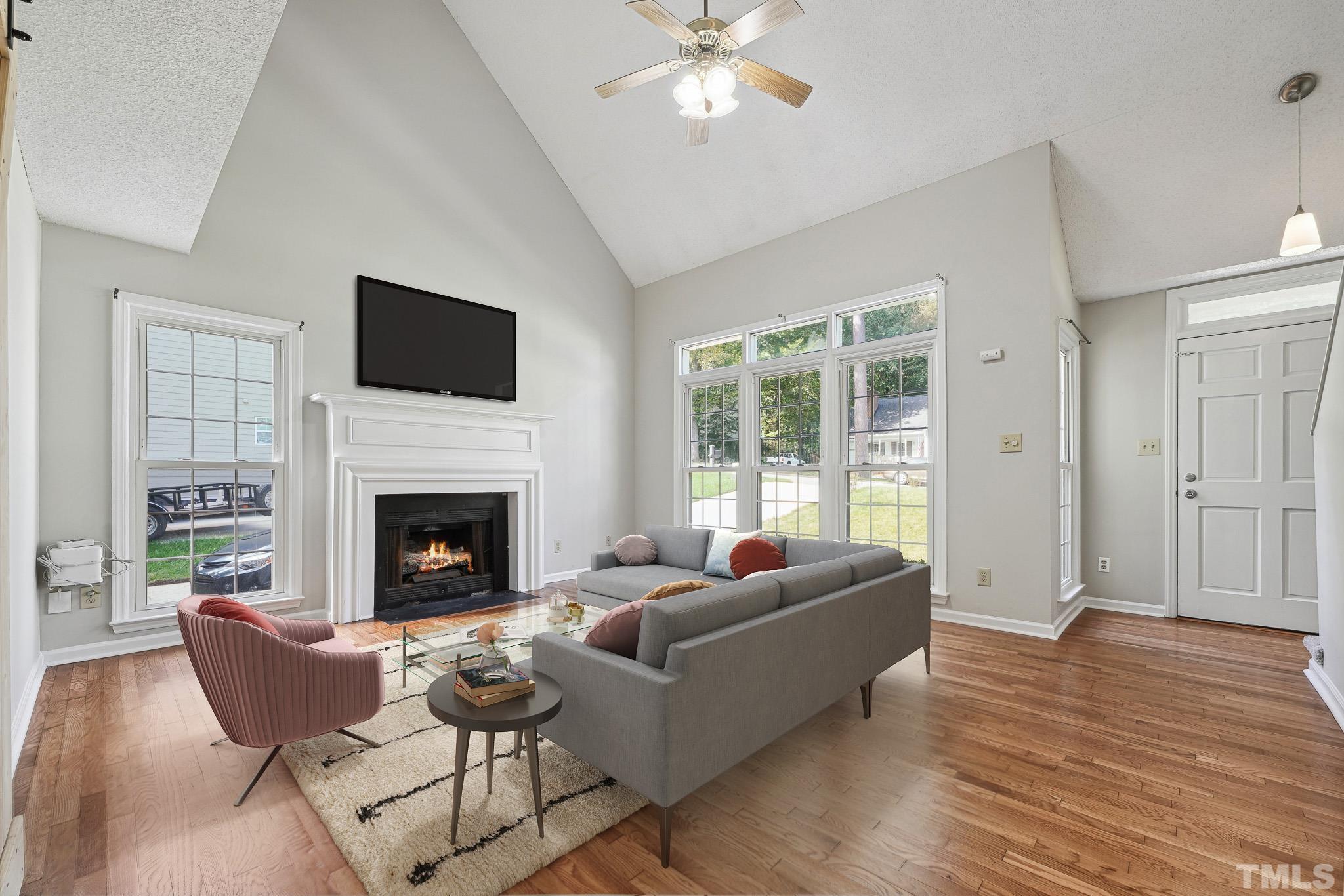 6712 Hammersmith Drive Raleigh, NC 27613 - Photo 3 of 26 a living room with furniture a fireplace and a flat screen tv