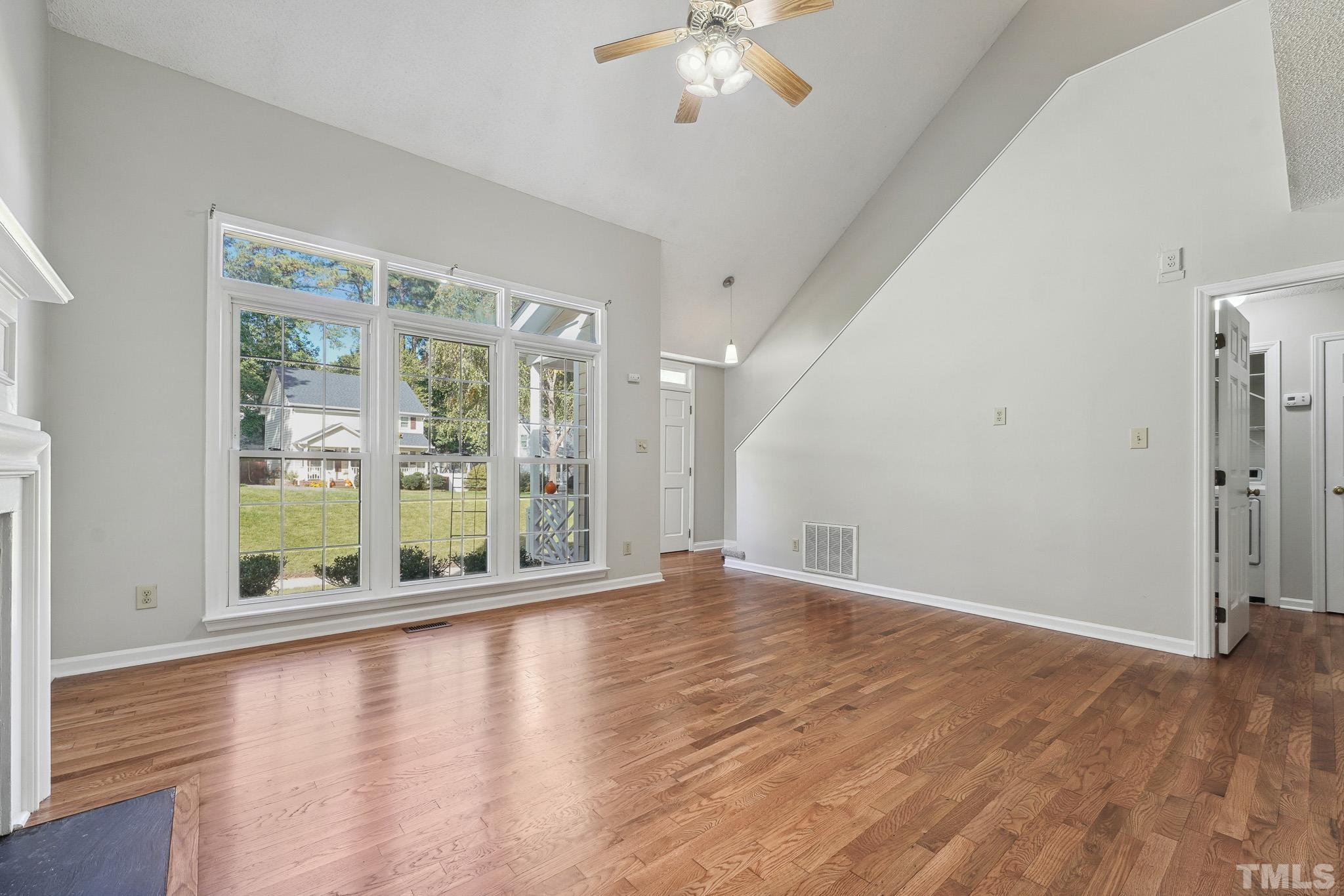 6712 Hammersmith Drive Raleigh, NC 27613 - Photo 5 of 26 a view of an empty room with wooden floor and a window