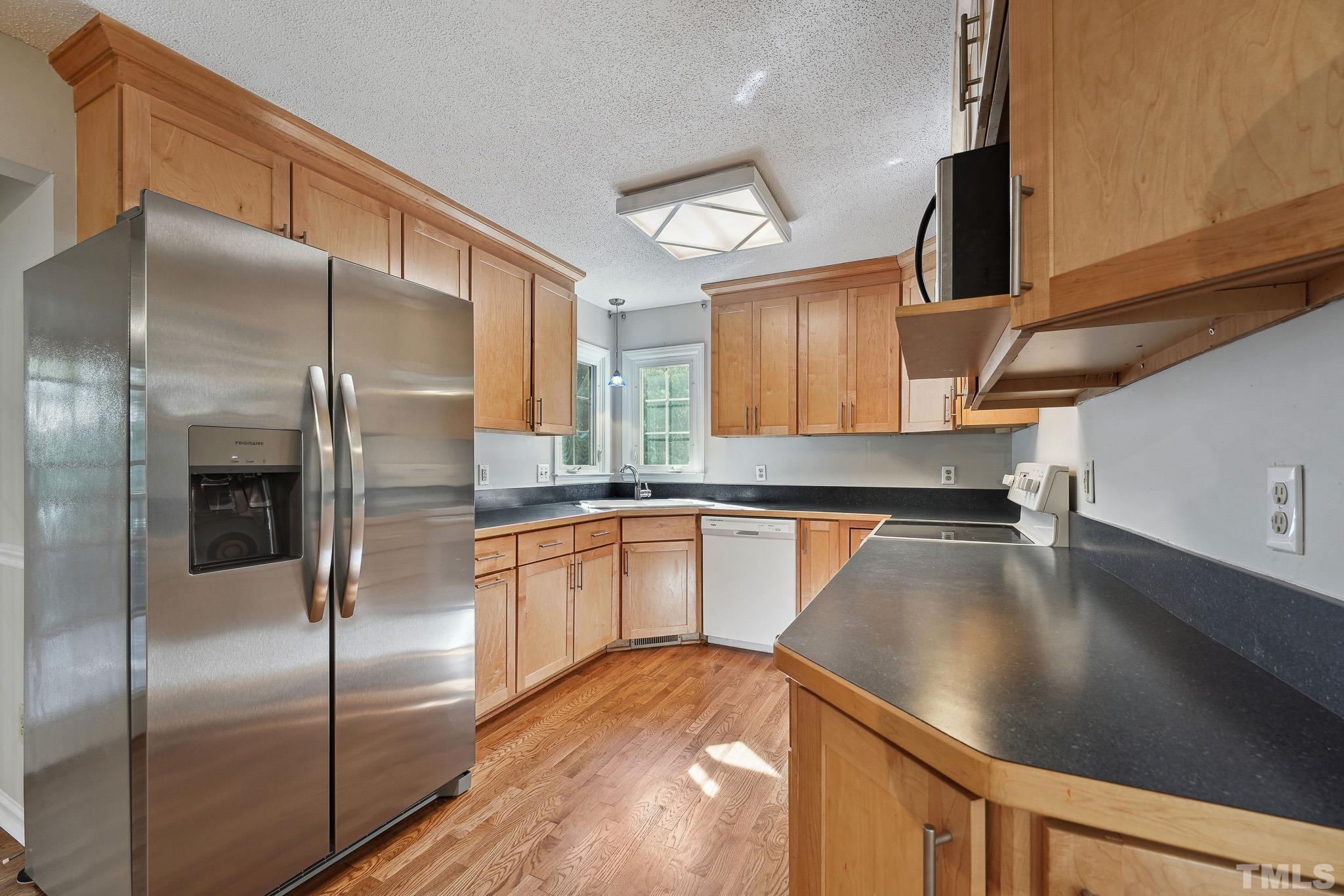 6712 Hammersmith Drive Raleigh, NC 27613 - Photo 8 of 26 a kitchen with stainless steel appliances granite countertop a refrigerator a sink and a stove