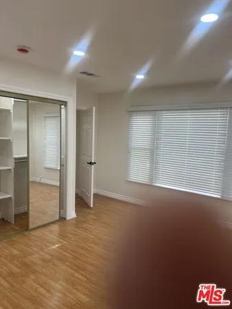 an empty room with windows and closet