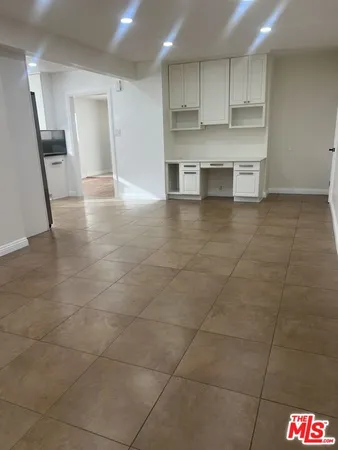 a view of kitchen with kitchen island sink and cabinets