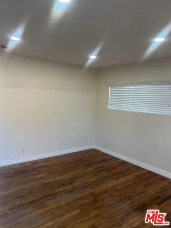 an empty room with wooden floor and closet