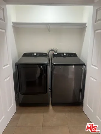 a view of a hallway with wooden floor and a bathroom
