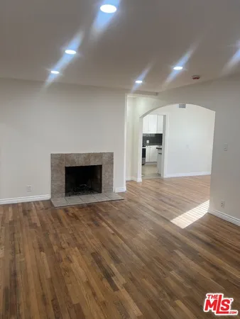a view of empty room with wooden floor and fireplace