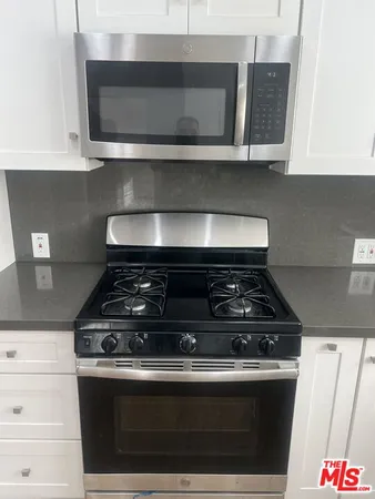 a stove top oven sitting inside of a kitchen