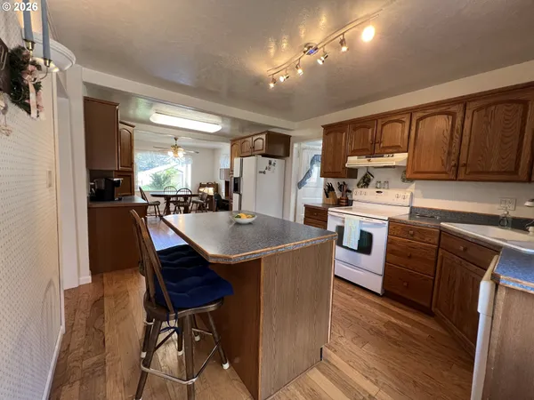 a kitchen with a stove a sink a dining table and chairs