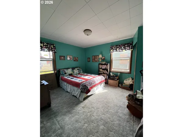 a bedroom with a bed and a large mirror
