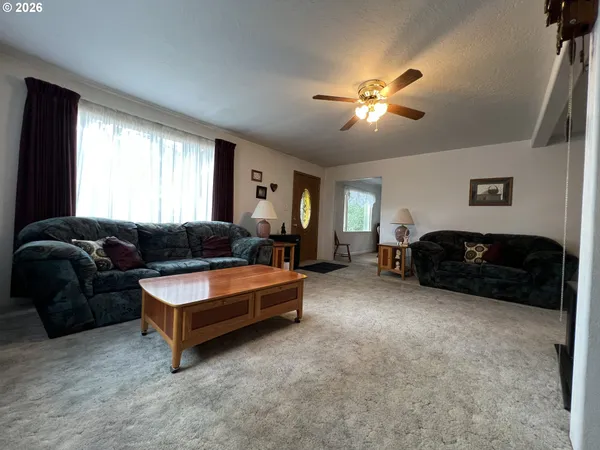 a living room with furniture ceiling fan and a window