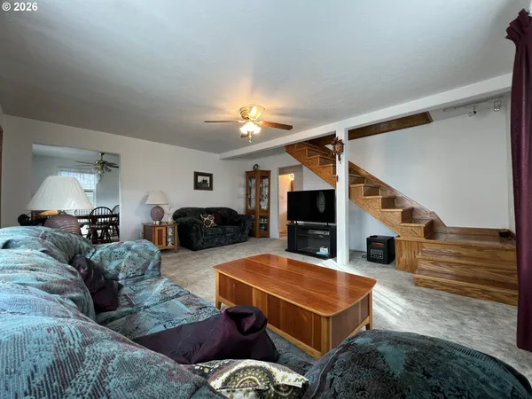 a living room with furniture a ceiling fan and a rug