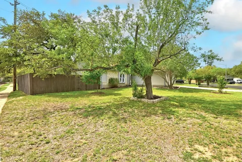 a house with huge green field with large tree