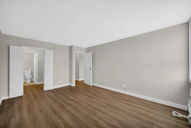 a view of an empty room with wooden floor