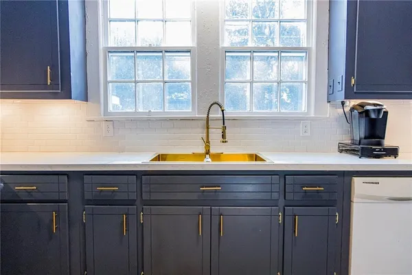 a view of kitchen with sink microwave and cabinets