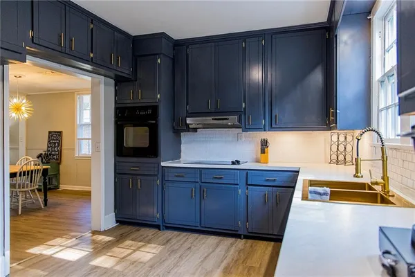 a kitchen with wooden cabinets and center island with wooden floor